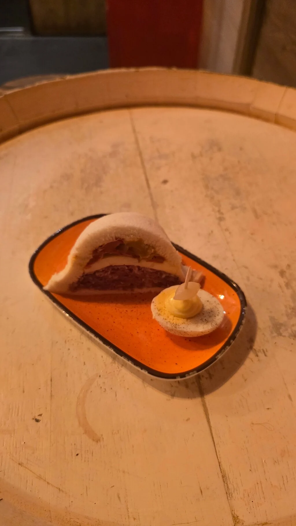 A glass of orange spritz on a round marble bar table